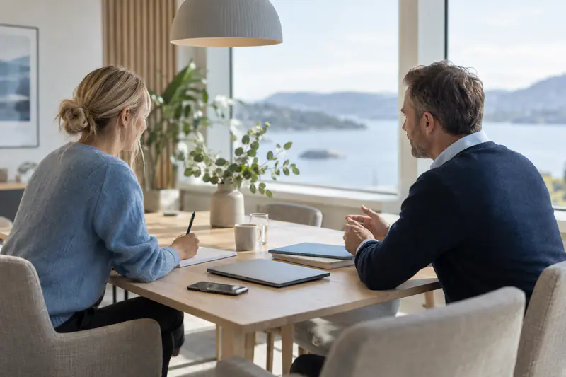 En IT-konsulent og en kunde snakker om support og fornyelse rundt et møtebord